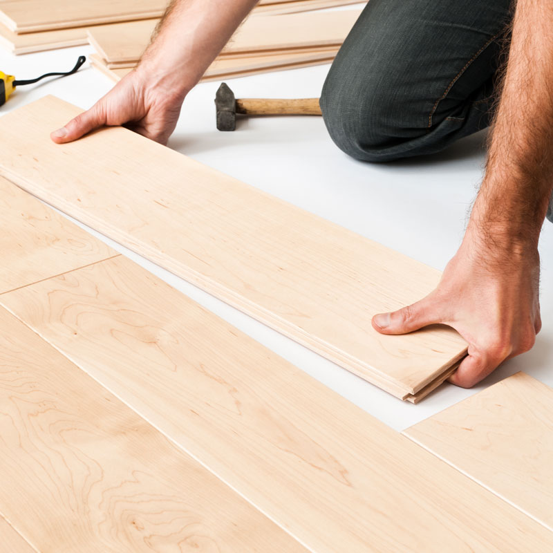 someone installing wood plank flooring